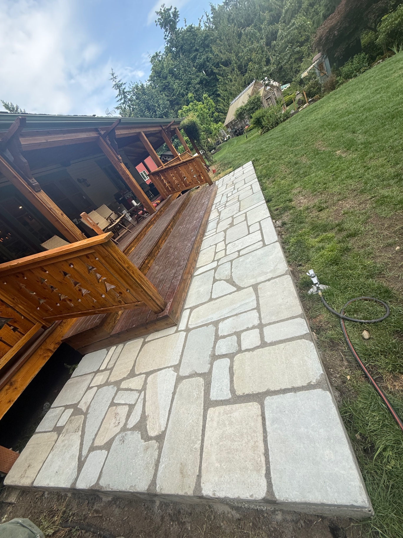 Custom flagstone walkway alongside a cedar deck