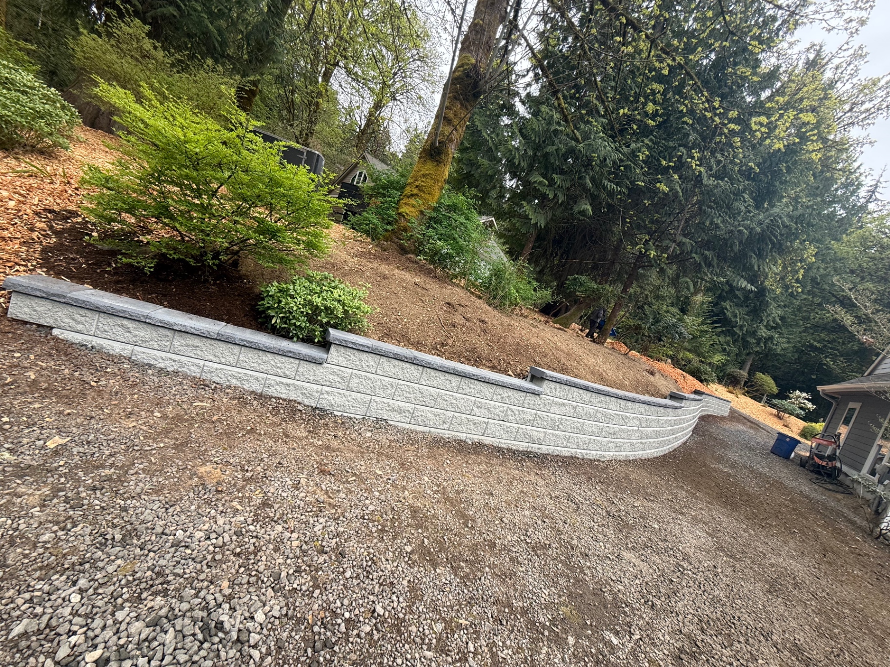 Long tiered retaining wall along a wooded slope