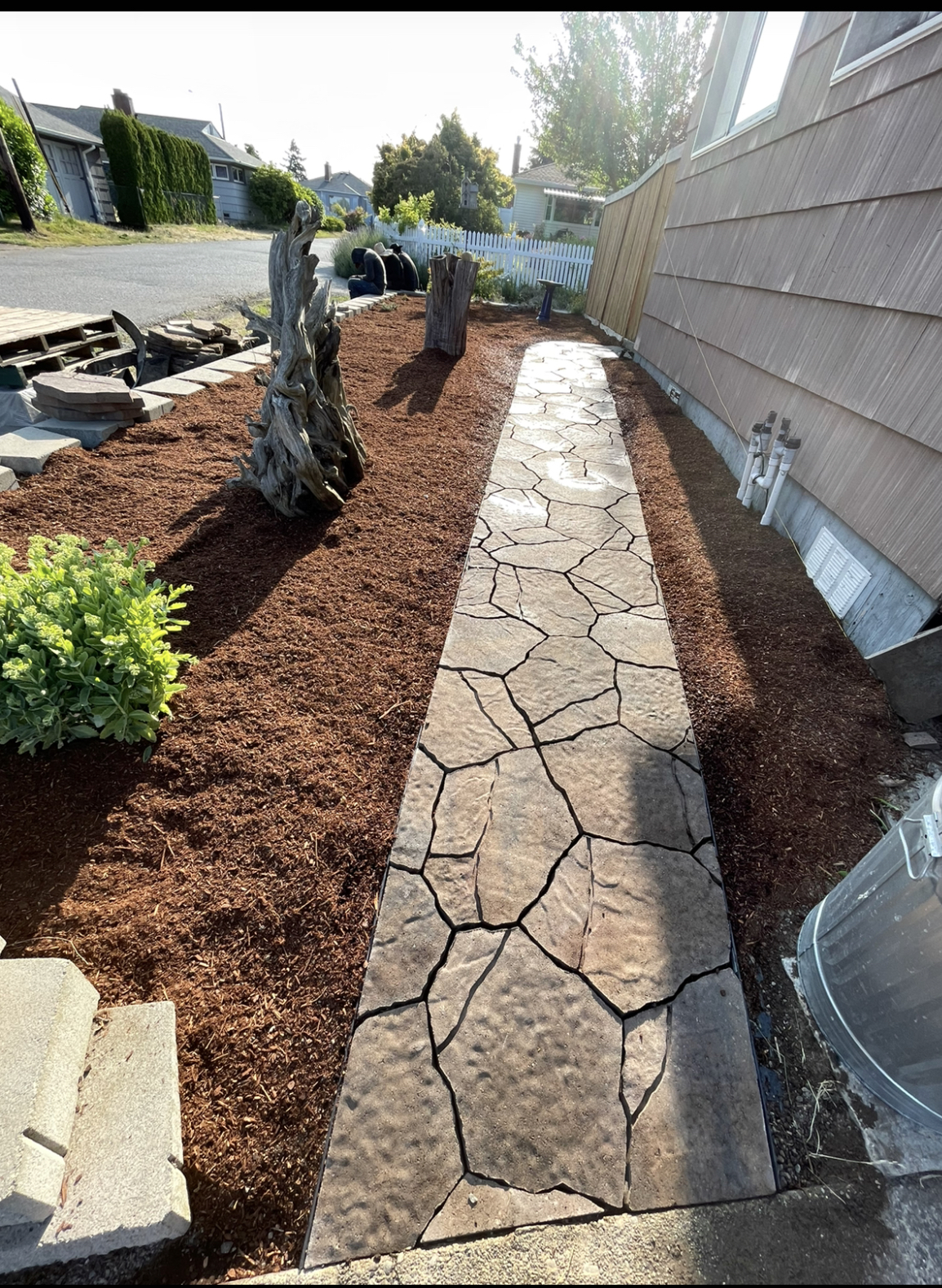 Stamped concrete flagstone walkway with fresh mulch beds