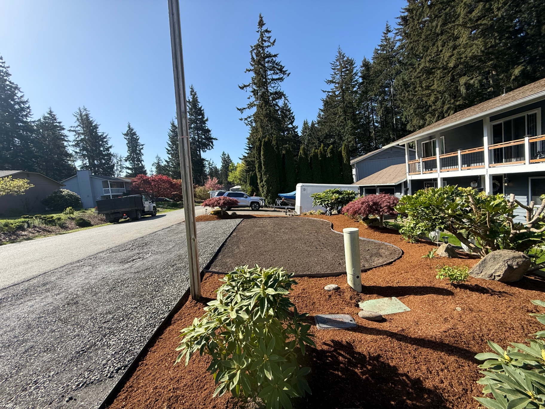Fresh mulch installation around curved planting bed