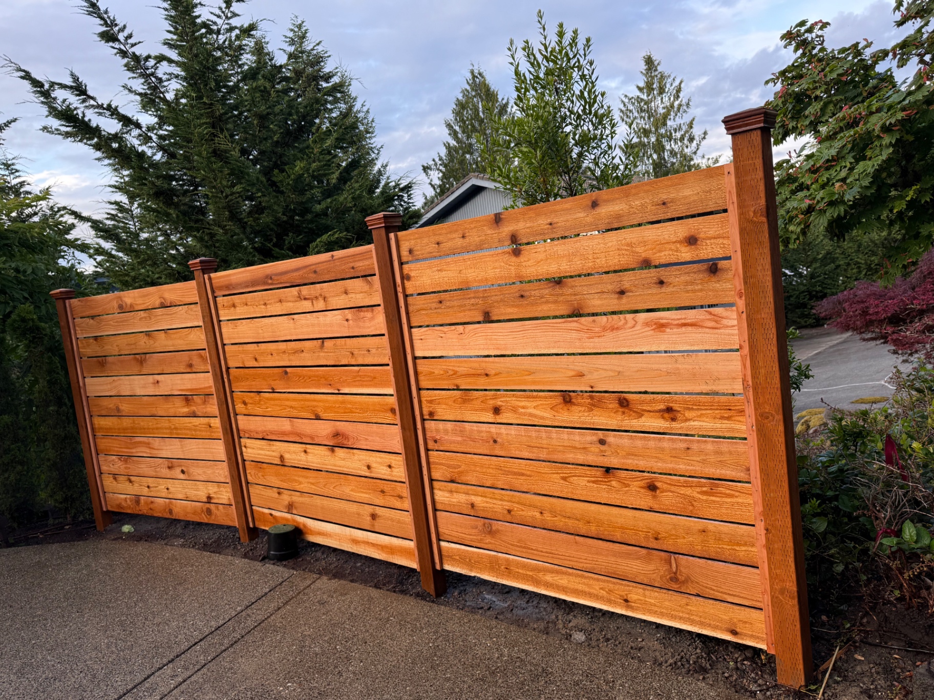 Custom horizontal cedar privacy fence with decorative post caps